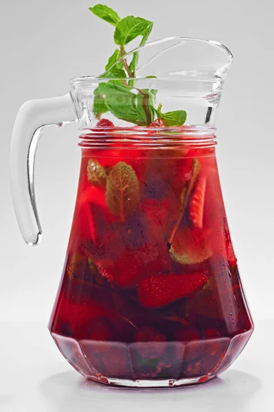Buzlu, ahududulu ve nane şekerli soğuk çilek içeceği beyaz tenli cam kavanozda izole edilmiş.