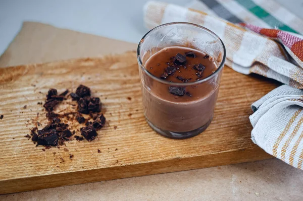 Bir bardak nefis, sıcak kakao içeceği. Tahta tahtada siyah çikolata ve peçeteli.