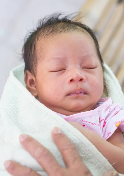 Çocuk annesinin kollarında yatıyor.