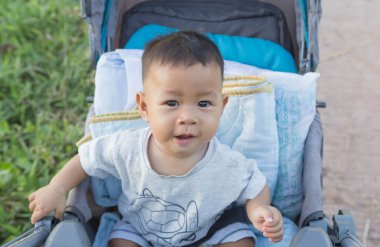 Çocuklar bir bebek arabası oturuyorlar.