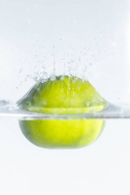 Limon beyaz arka planda suya düşüyor.