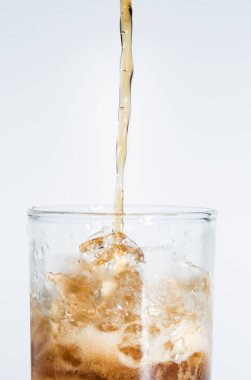 Siyah su beyaz arka planda bir bardağa düşer..