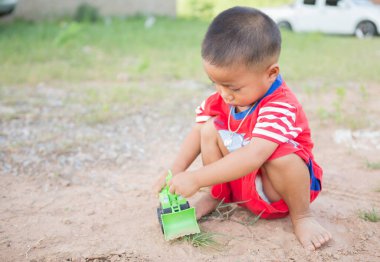 Oyuncak kepçe oynayan bir çocuk.