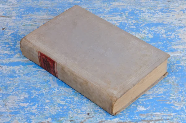 Vintage book in gray binding on a blue background. View from above.