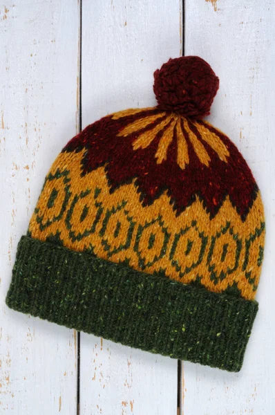 Örme şapka Beyaz ahşap zemin üzerinde. Yukarıdan görüntülemek.