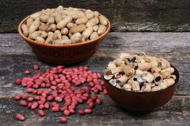 Bir tabakta soyulmuş fıstık ve kabuk. Ön görünüm.