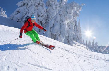 Yokuş aşağı mavi gökyüzü karşı yüksek dağlarda kayak kayakçı