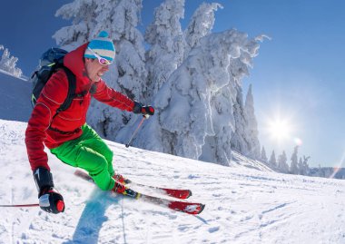 Yokuş aşağı mavi gökyüzü karşı yüksek dağlarda kayak kayakçı