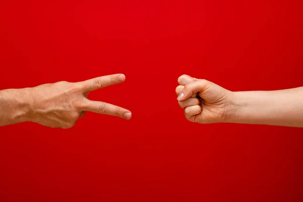 Rock-paper-scissors - woman wins with rock - red background