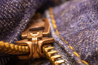 Bir fermuar çekme sekmesi ve dişler (denim kot)
