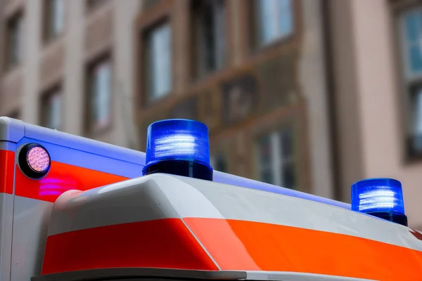 市街地で青いライトを点滅させてドイツ救急車 — ストック写真
