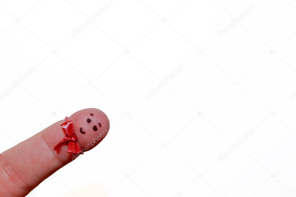 A finger with a happy face on it and a small red bow tie - white background