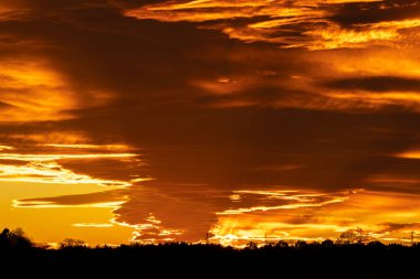 birkaç bulutlar ve güneş ışınları ile güzel bir turuncu günbatımı