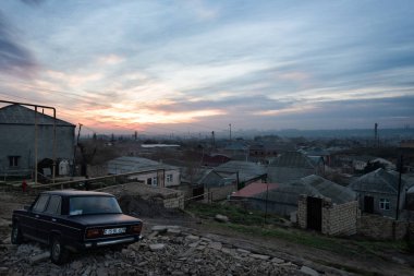 Gündoğumu ile eski bir Lada ön planda, Ocak 2019 alınan Azerbaycan Bakü eteklerinde üzerinden