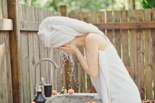 Vrouw in haar gezicht met water wassen. buiten badkamer — Stockfoto