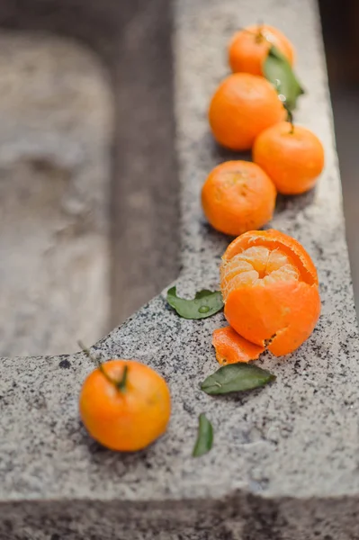 Fresh mandarin oranges fruit or tangerines. Female hands holding ripe mandarins, close up