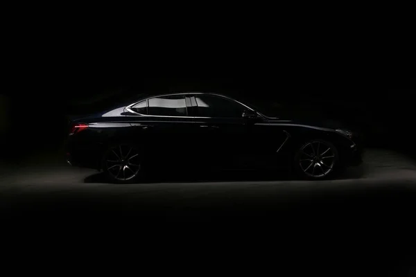 Silhouette de voiture de sport noire avec phares sur fond noir — Photo