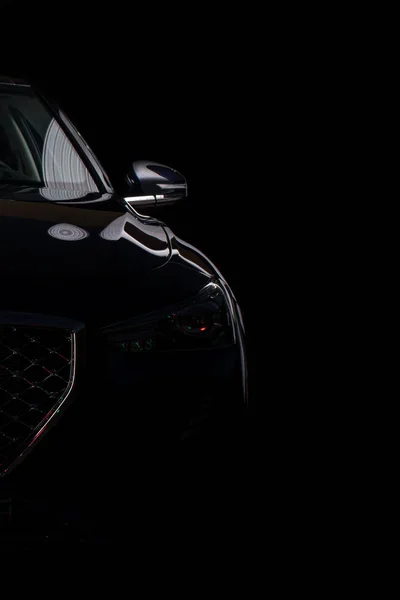 silhouette of black sports car with headlights on black background