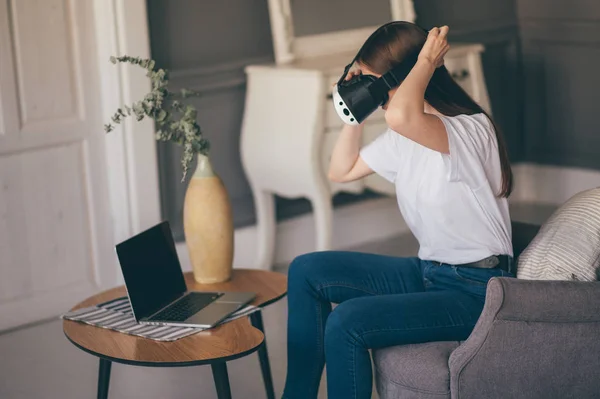 Jeune femme utilise des lunettes de réalité virtuelle dans un bel appartement — Photo