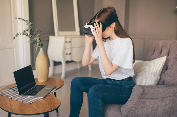 Jonge vrouwelijke programmeur test een nieuwe app met virtual reality glazen in huis — Stockfoto