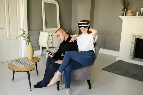 Молодой человек и женщина используют виртуальную реальность в гостиной — стоковое фото