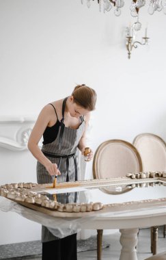 Büyük ahşap resim çerçevesi üzerinde çalışan kadın esnaf elleri