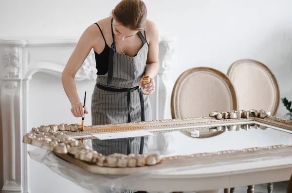 Mani artigianali femminili che lavorano su una grande cornice in legno — Foto Stock