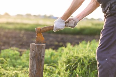 Adam eski balta ile ahşap doğrama olduğunu. yakın çekim, gün batımı