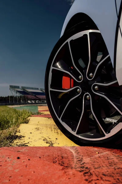 A bela roda de um carro esporte, com o asfalto, em uma pista de corrida. carro esporte na pista — Fotografia de Stock