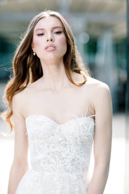 Gelinin güzel portresi moda gelinliği içinde tüylü, lüks makyaj ve saç stili.