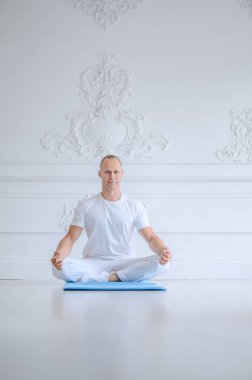 Adam beyaz bir arka plan karşı gelişmiş yoga pratik