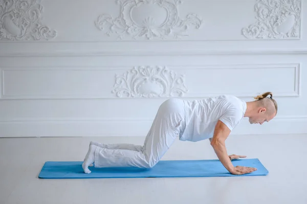 Mann praktiziert fortgeschrittenes Yoga vor weißem Hintergrund — Stockfoto