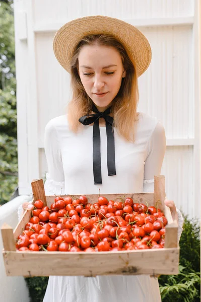 Donna felice con ciliegie indossando cappello e vestito bianco. Note di alimentazione, dieta, cibo vegetariano e concetto di persone — Foto Stock