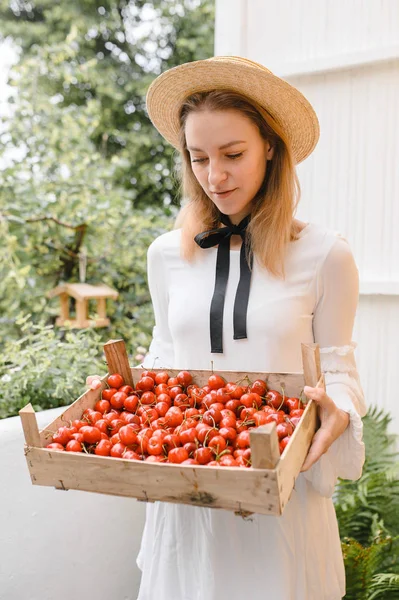 Donna felice con ciliegie indossando cappello e vestito bianco. Note di alimentazione, dieta, cibo vegetariano e concetto di persone — Foto Stock