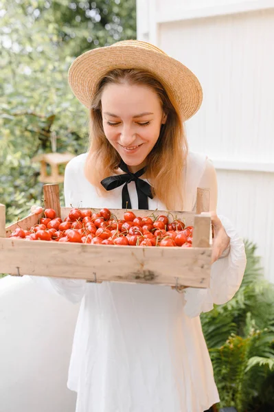 happy woman with cherries wearing hat and white dress. Healthy eating, dieting, vegetarian food and people concept