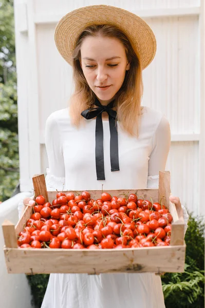 Donna felice con ciliegie indossando cappello e vestito bianco. Note di alimentazione, dieta, cibo vegetariano e concetto di persone — Foto Stock