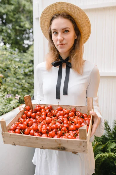 Donna felice con ciliegie indossando cappello e vestito bianco. Note di alimentazione, dieta, cibo vegetariano e concetto di persone — Foto Stock