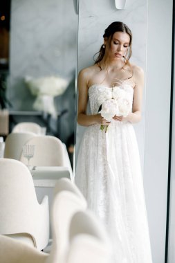  Gelin güzel bir restoranda gelinlik giyiyor.