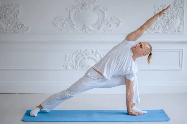 Mann beim Yoga zu Hause. Fitness, Yoga und gesundes Lebensstil-Konzept — Stockfoto