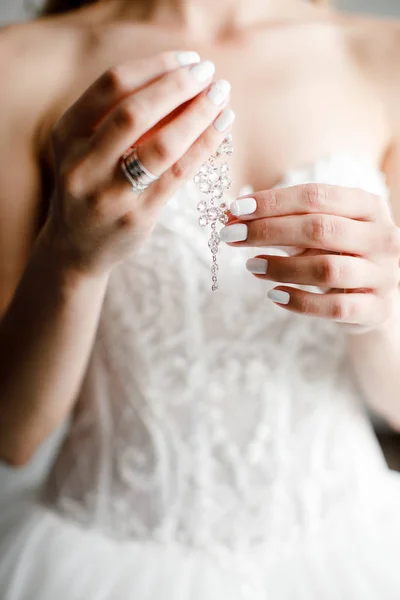 Nevěsta drží náušnice zblízka. — Stock fotografie
