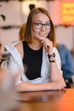 Siyah gözlüklü güzel çekici kadın. Masada oturan bir kafede çalışan mutlu iş kız