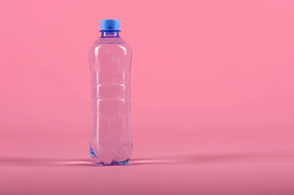 Plastic bottle of still healthy water isolated on pink background