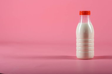  pembe bir arka plan üzerinde süt şişesi. alay etmek