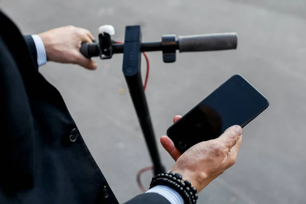 Imagem de perto de um homem em uma scooter elétrica pagando online — Fotografia de Stock