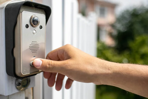 Der menschliche Finger drückt die Taste der Video-Gegensprechanlage. Landhaus-Hintergrund — Stockfoto