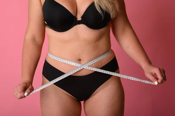 Size plus girl with measuring tape around the waist. Body positive — Stock Photo, Image