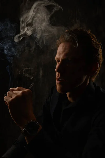 Muž kouří cigaretu. Cigaretový kouř šíření. — Stock fotografie