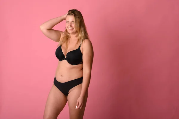 Pembe arka planda siyah iç çamaşırı güzel şişman kız