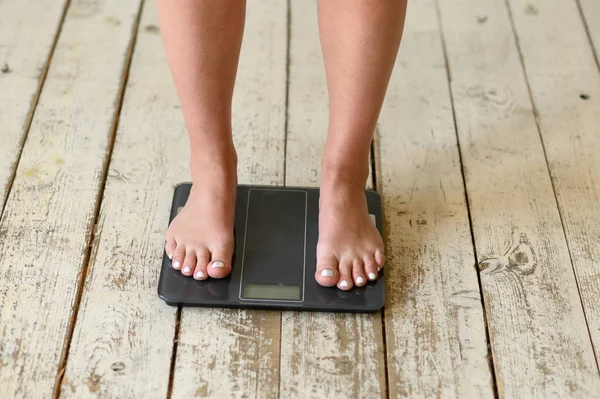 Girl standing on scales. Body positive. Size plus