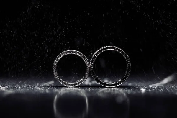 검은 색 배경에 다이아몬드가 있는 두 개의 웨딩 링 — 스톡 사진